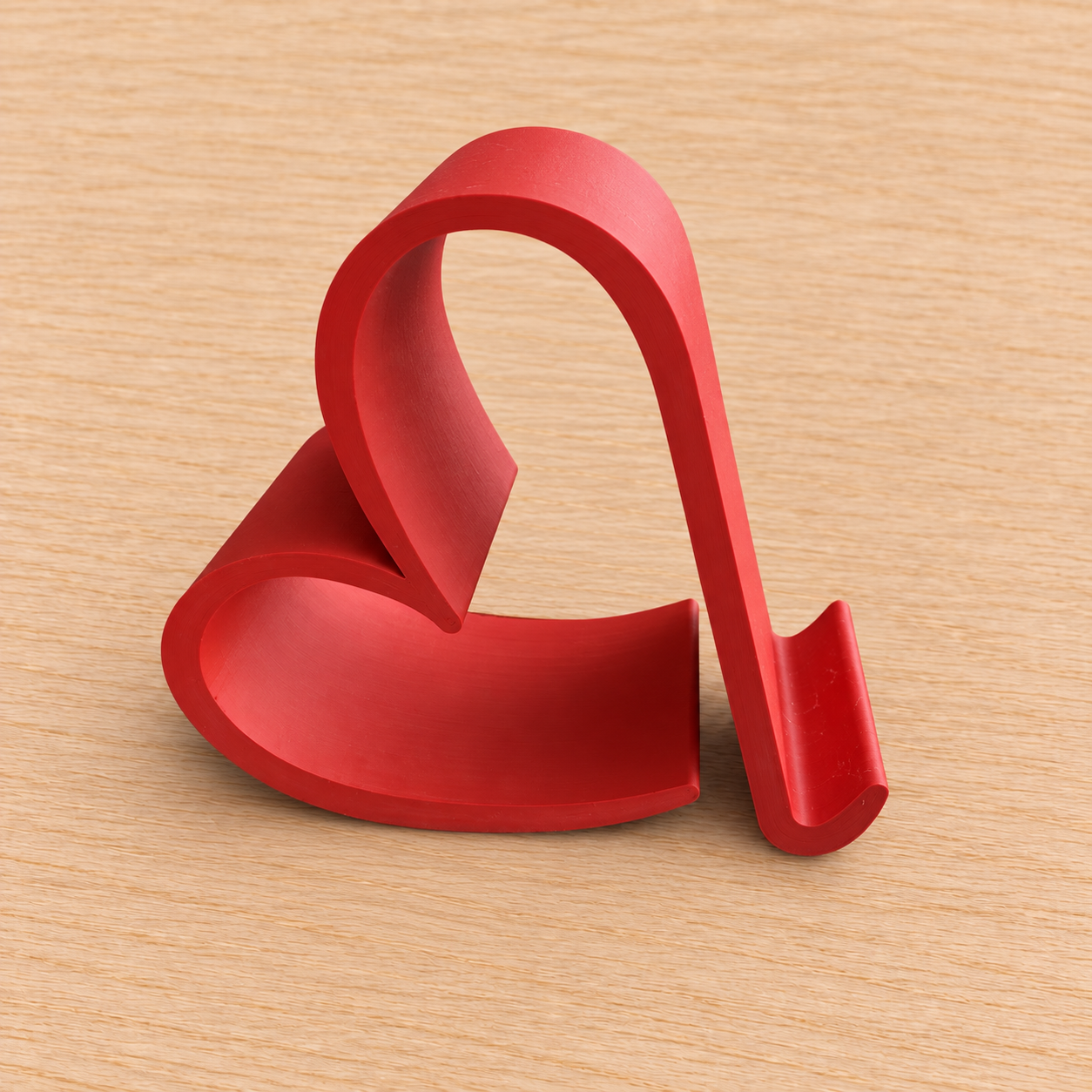 Cuore PixThinkLab: supporto per telefono stampato in 3D, presentato su legno chiaro.
