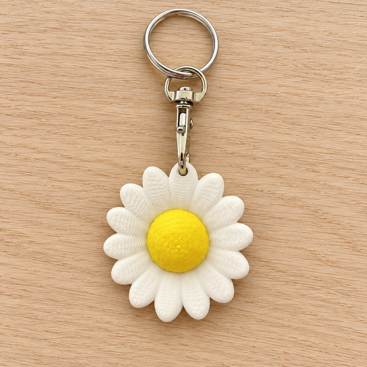 Portachiavi Margherita bianco e giallo stampato in 3D, completo di anello e moschettone, su legno chiaro