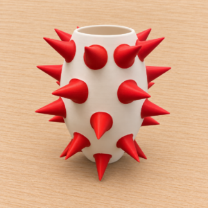 Vaso modulare Spike bianco avorio con punte rosse, stampato in 3D, su sfondo in legno chiaro